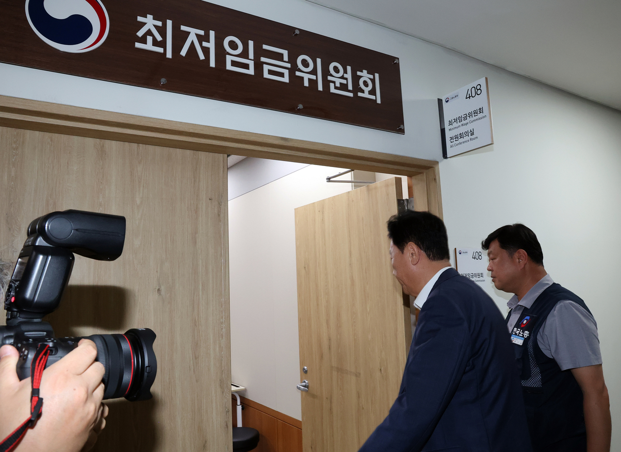 더탑 토토사이트위원회 사용자위원인 류기정 한국경영자총협회 전무(왼쪽)와 근로자위원 류기섭 한국노총 사무총장이 10일 정부세종청사에서 열린 더탑 토토사이트위원회 제12차 전원회의에서 민주노총 위원들이 심의를 거부한 채 퇴장해 회의가 정회된 후 밖에서 얘기를 나누고 들어오고 있다. 연합뉴스