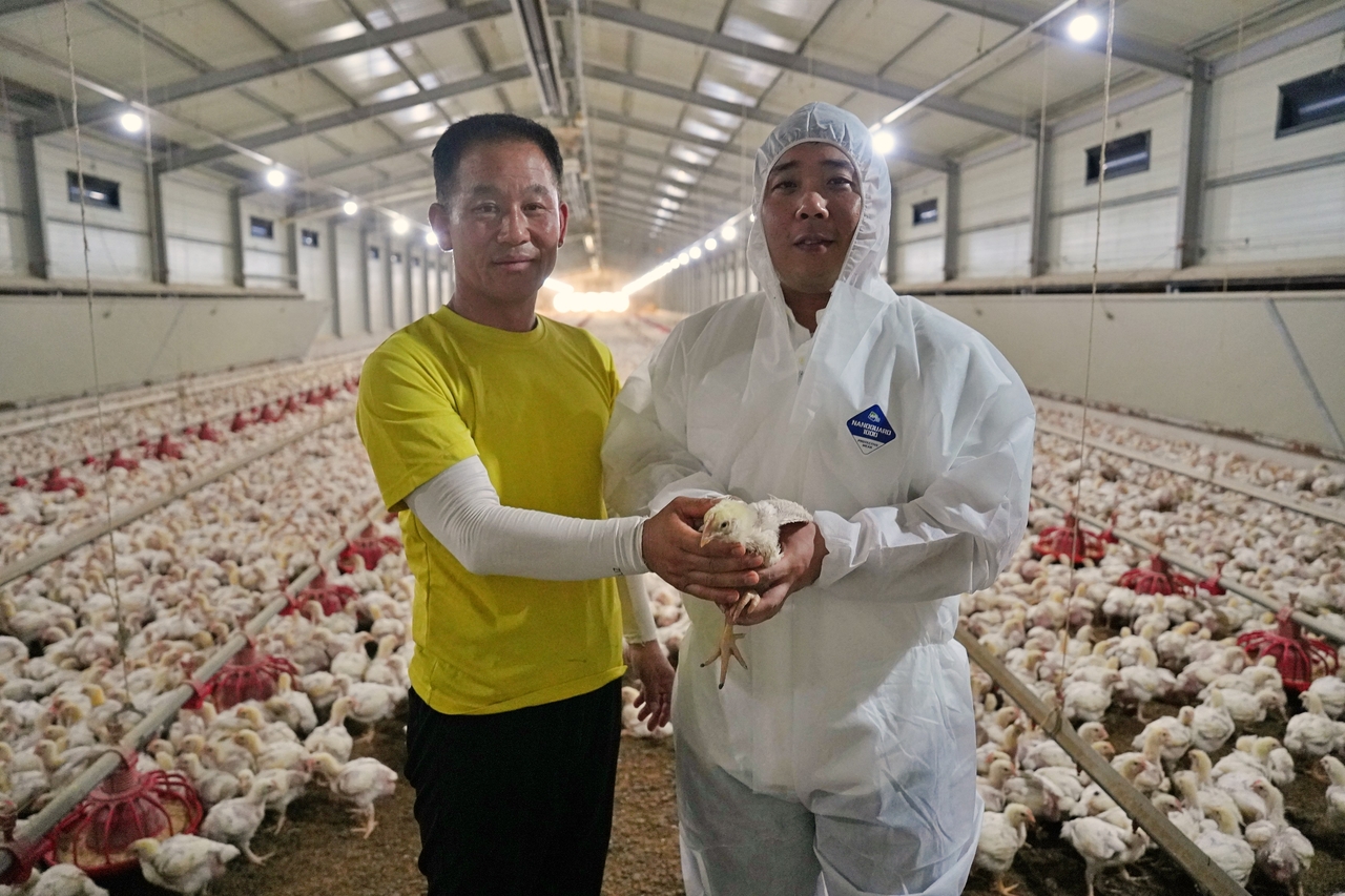 전북 익산시에 있는 양계장에서 류재한(왼쪽) 농장주와 이근우 롯데마트·슈퍼 축산팀 MD가 사진을 촬영하고 있다. [롯데마트 제공]