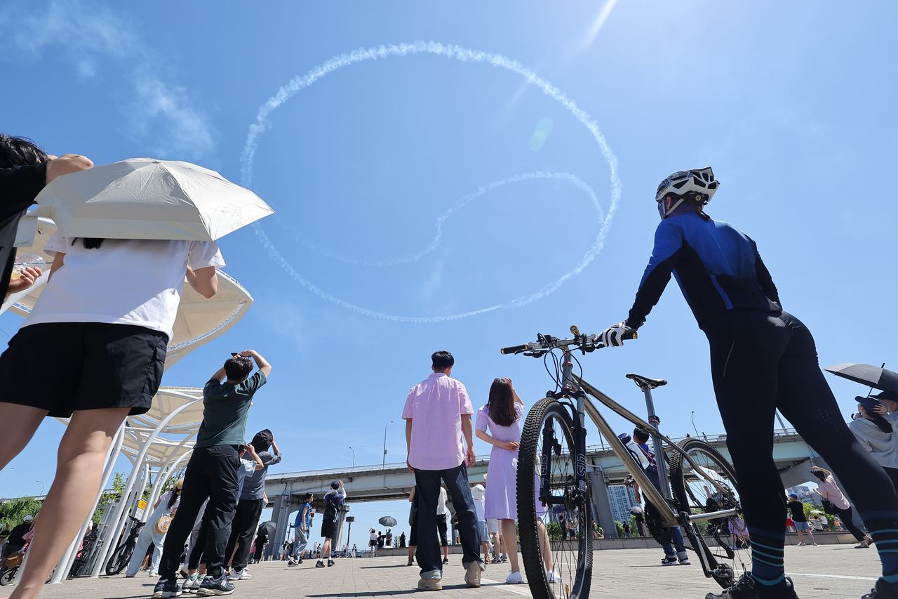 The South Korean Air Force’s Black Eagles aerobatic team draws a Taeguek pattern — the symbol at the center of the national flag — with smoke trails during a performance above the Han River in Seoul on Saturday, commemorating the inaugural K-Defense Day on July 8. (Yonhap)