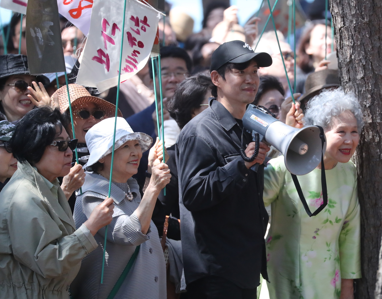 Actor-director Yoo Jun-sang (second from right) and actor Park Jeong-ja (first from right) is seen here at a set for the film "Between Cheongmyeong and Gogu" at Sunpo Beach in Gangneung, Gangwon Province, Sunday. (Yonhap)