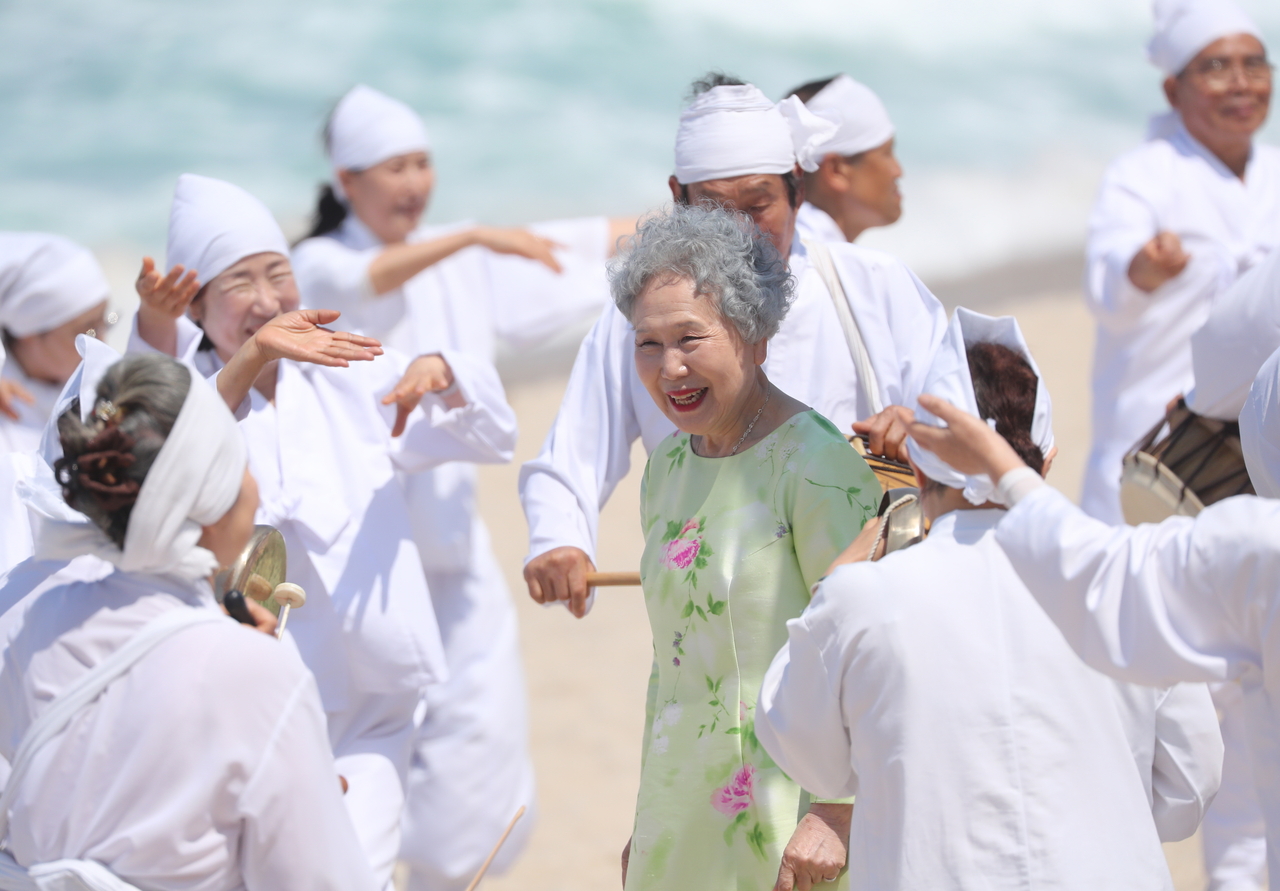 Park Jeong-ja (center) performs a funeral scene for the film "Between Cheongmyeong and Gogu" at Sunpo Beach in Gangneung, Gangwon Province, Sunday. (Yonhap)