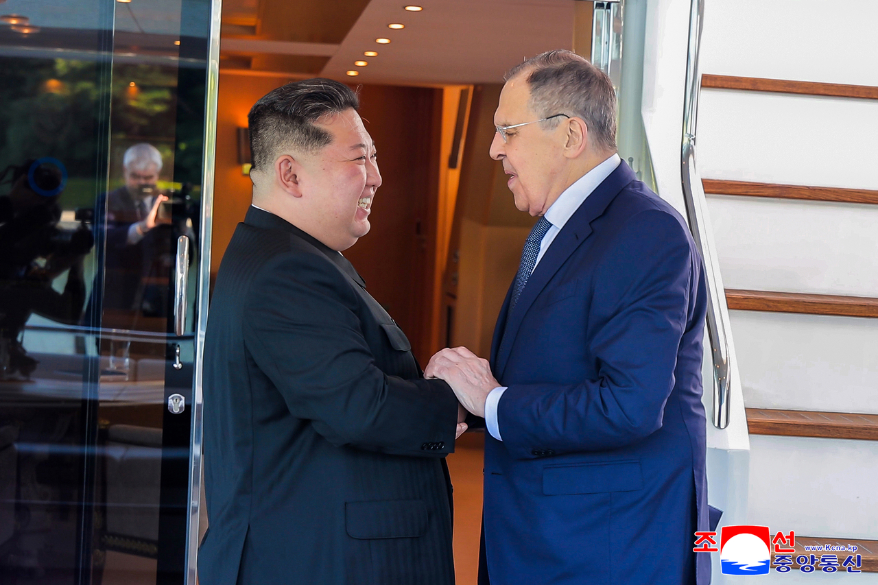 This image, published by the Korean Central News Agency on Sunday, shows North Korean leader Kim Jong-un (left) and Russian Foreign Minister Sergey Lavrov holding hands during a meeting held the previous day in Wonsan, Kangwon Province. (KCNA-Yonhap)