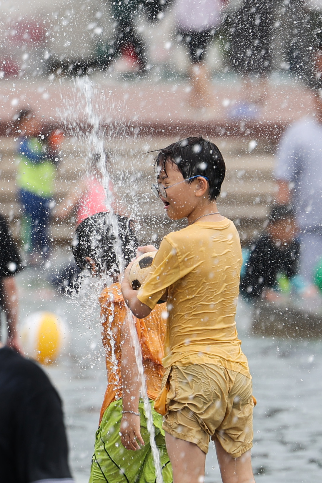 A young boy stands in a fountain in the pool in Yeouido Water Light Square, Seoul, on Sunday. (Yonhap)