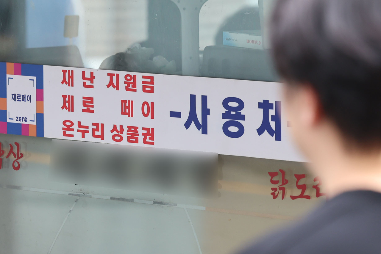 A sign on a restaurant indicates that it accepts local business vouchers. (Newsis)