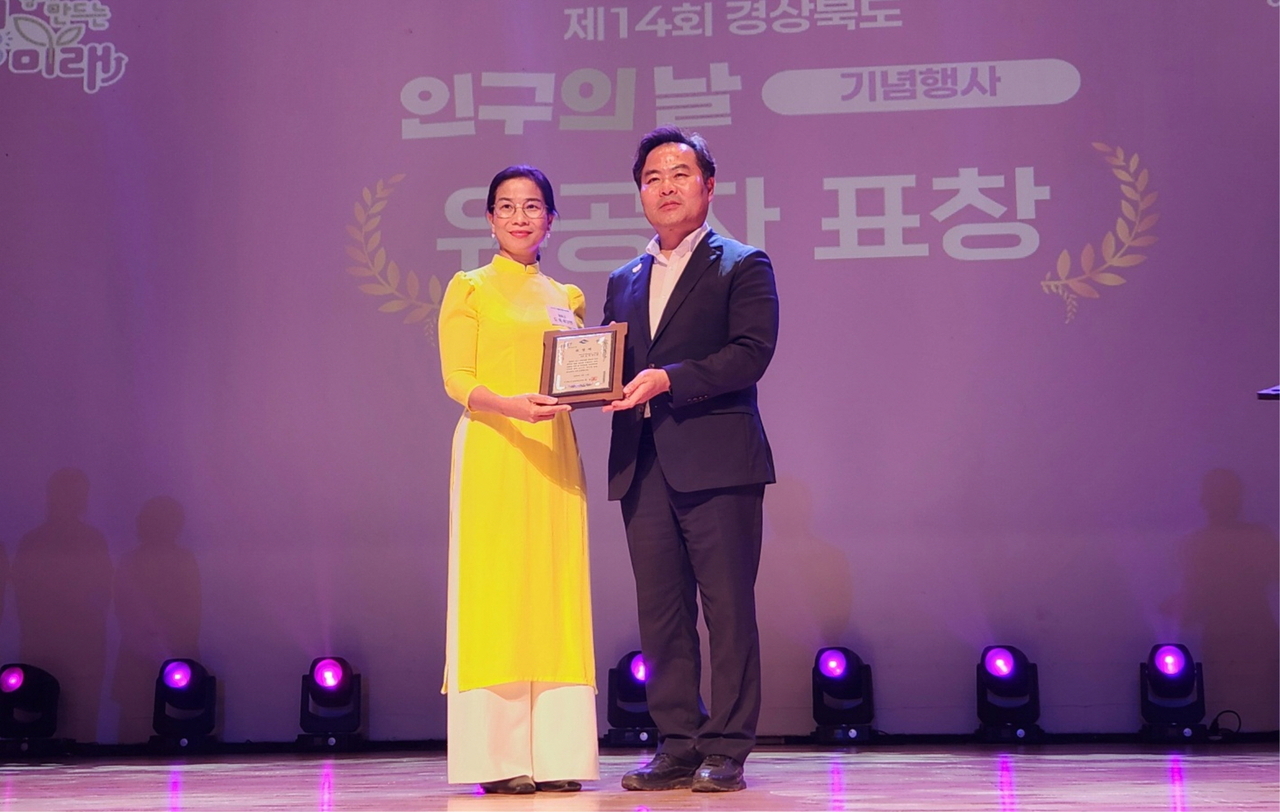 도옥 루이엔’ 베트남 푸자민(Puzamin) 공동체 대표(왼쪽)가 경북 영천시에서 열린 세계 인구의날 행사에서 김학홍 경북도 행정부지사로부터 도지사 표창을 수여 받고 기념촬영을 하고 있다.[봉화군제공]