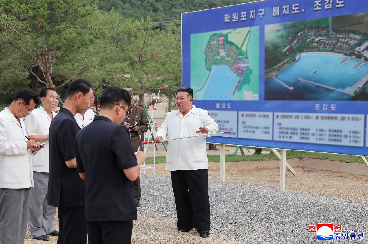 This photo shows the North's leader Kim Jong-un (right) inspecting the construction site of the Ragwon County Offshore Farm in South Hamgyong Province on Sunday.  (Yonhap)