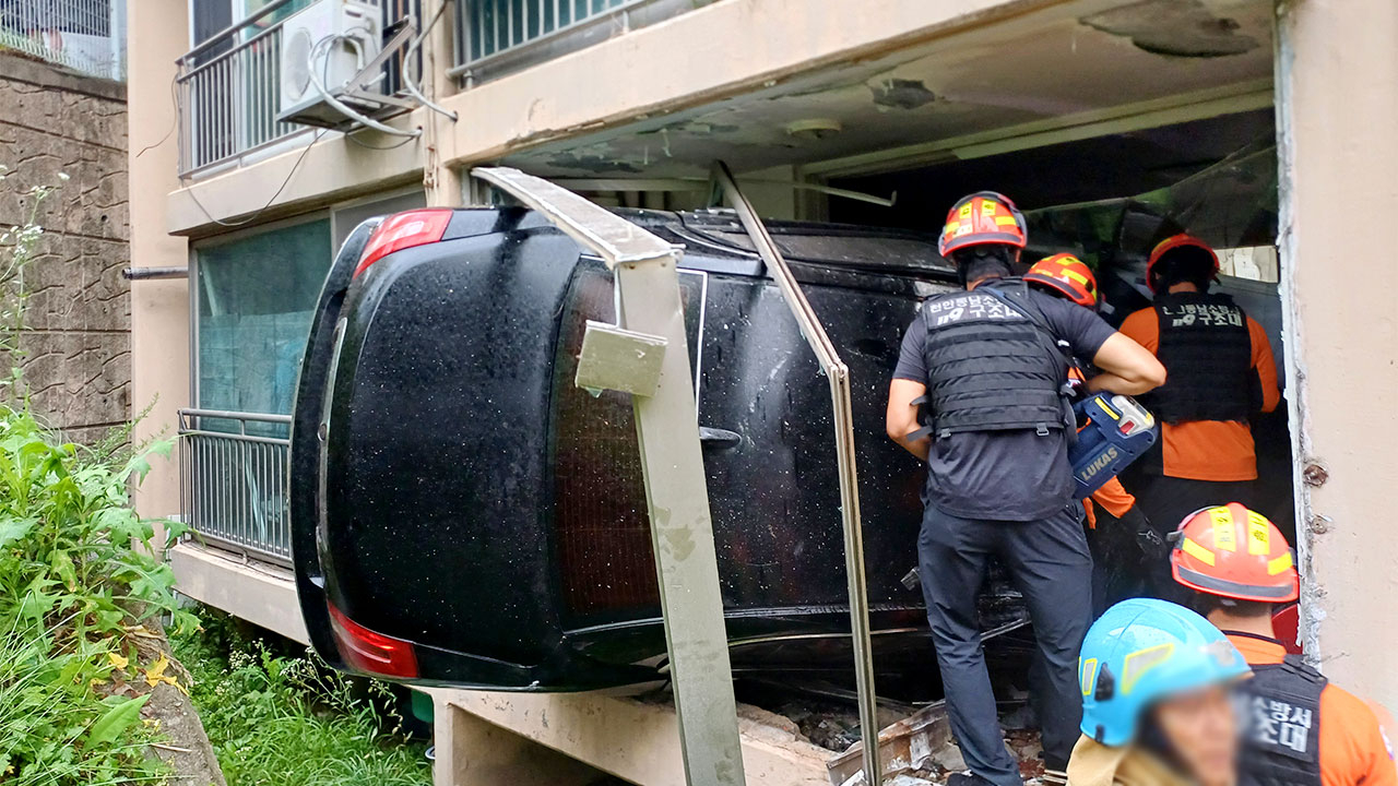 Emergency responders work on Monday at the scene after a car plunged off a roadside and crashed into a first-floor apartment balcony in Cheonan, South Chungcheong Province, Sunday. (Cheonan Dongnam Fire Station)
