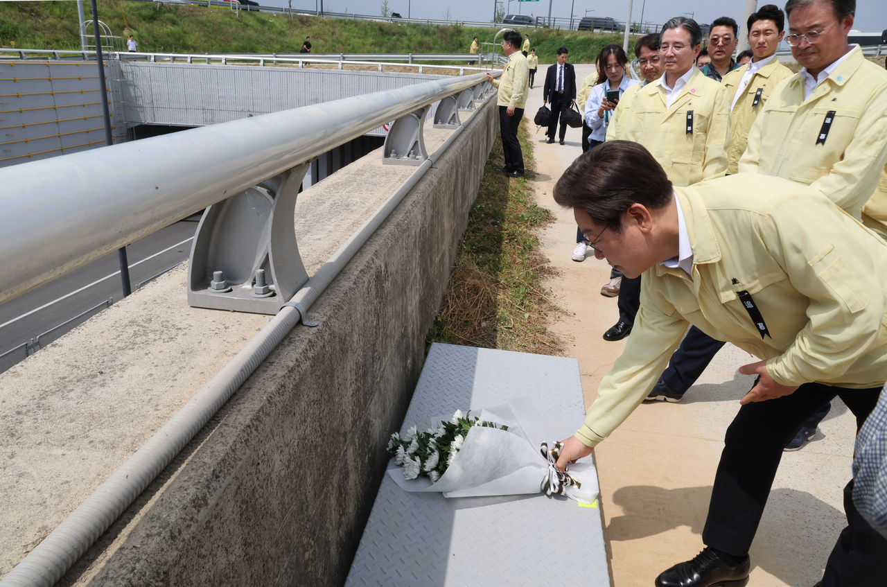President Lee Jae Myung (front) lays flowers at the site of deadly flood in Osong of Cheongju, North Chungcheong Province, Monday. (Pool photo via Yonhap)