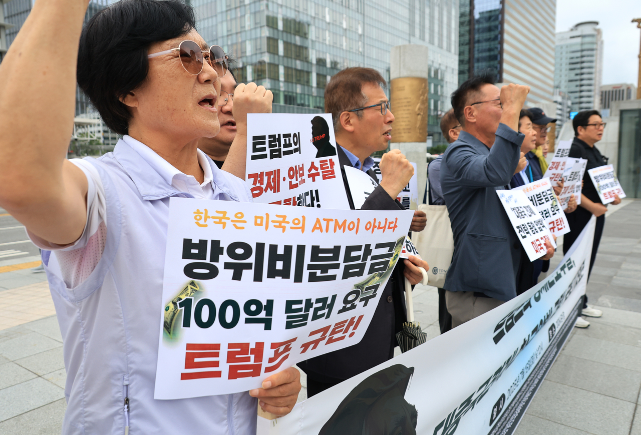 Civic groups protest against US President Donald Trump's "reciprocal" tariffs, including 25 percent duties on South Korea, which are slated to go into effect Aug. 1, and growing pressure for South Korea to shoulder more defense costs to maintain US Forces Korea on the peninsula, in front of the US Embassy in Jongno-gu, Seoul, Tuesday. Yonhap