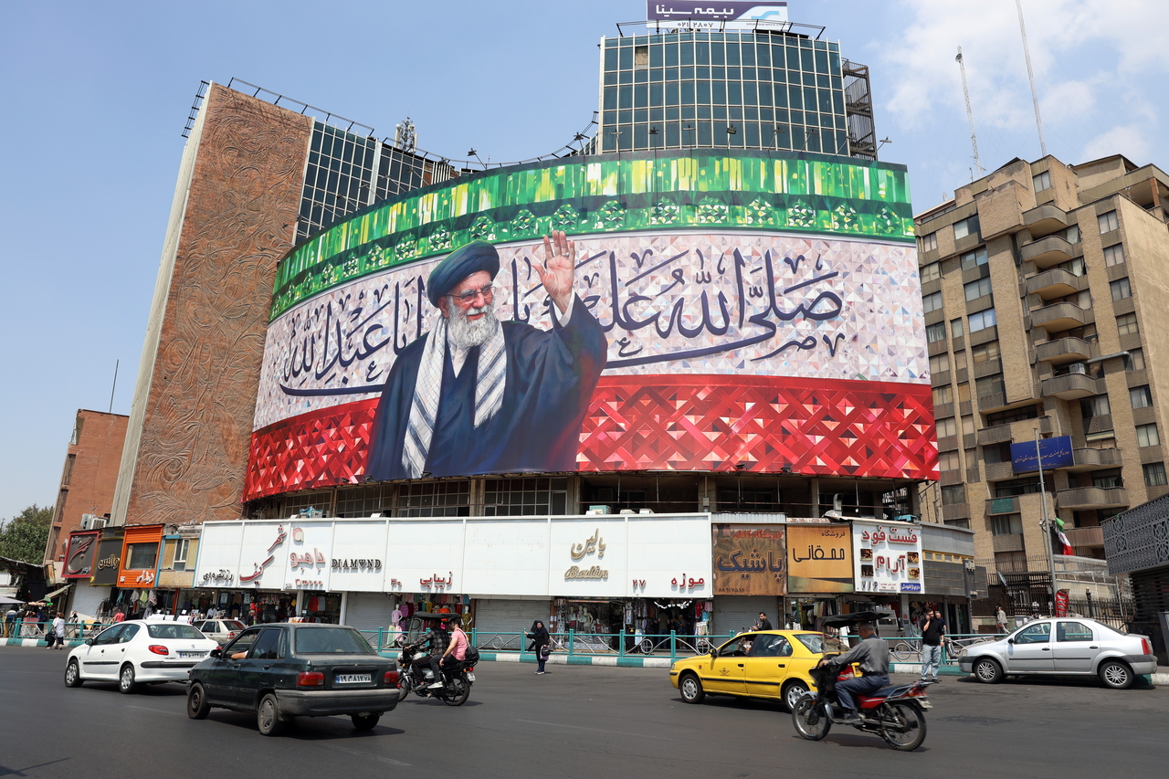Cars and motorbikes drive past a billboard featuring a picture of Iranian Supreme Leader Ayatollah Ali Khamenei at Valiasr Square in Tehran, Iran, Monday. (EPA-Yonhap)