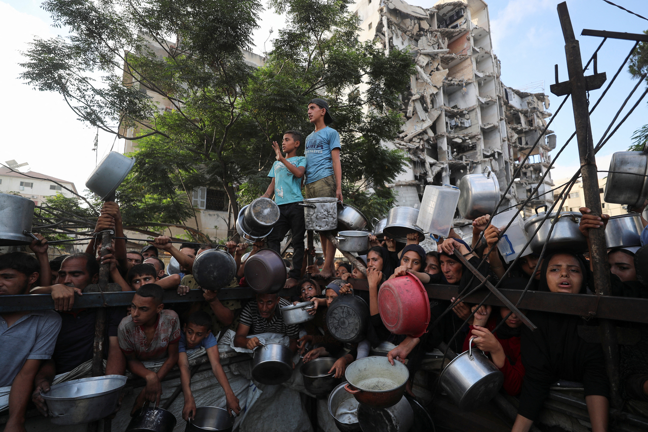 Palestinians wait to receive food from a charity kitchen in Gaza City, Monday. (Reuters-Yonhap)