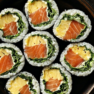 Plate of Korean salmon gimbap rolls, a classic sealed and stackable takeout food