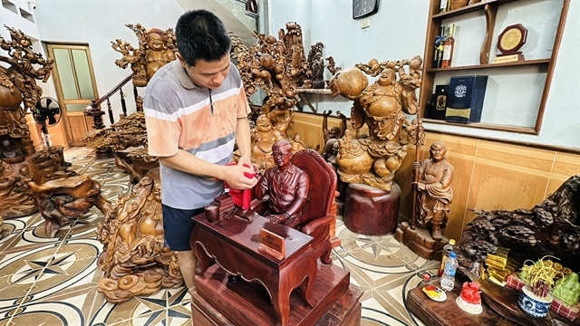 Vu Xuan En works on a wooden sculpture at his workshop at the Dong Giao wood carving village in Hai Phong City, Vietnam.    (Viet Nam News)