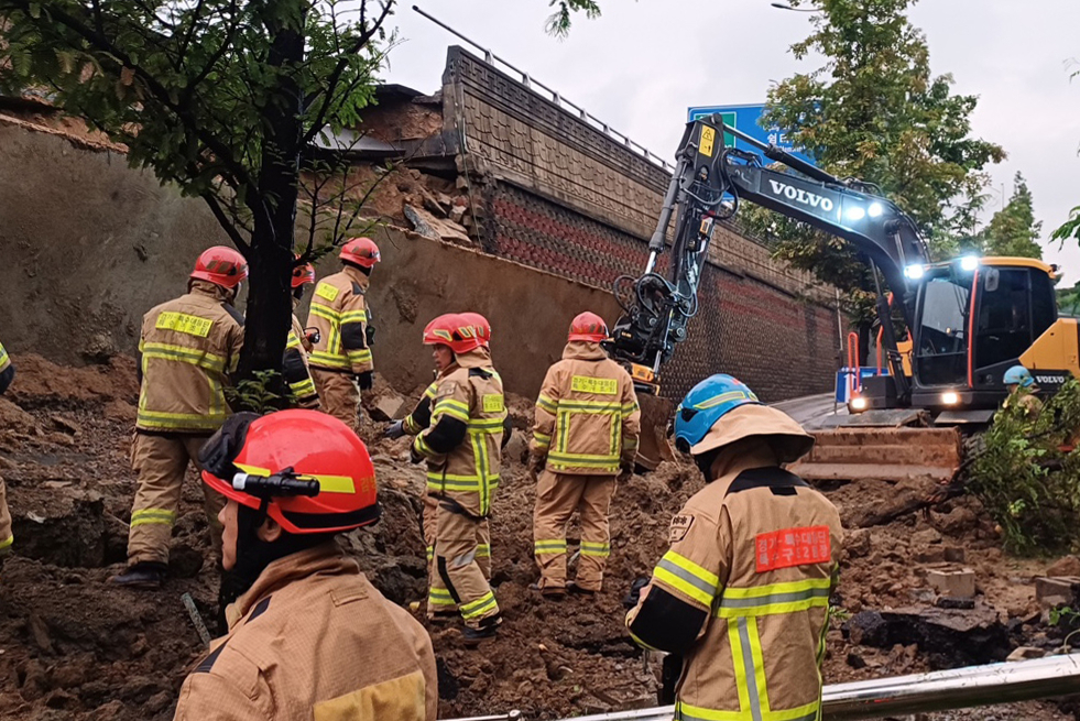 Rescue workers try to uncover a collapse of a retaining wall in Osan, Gyeonggi Province, Wednesday. (Gyeonggi Fire and Disaster Headquarters)