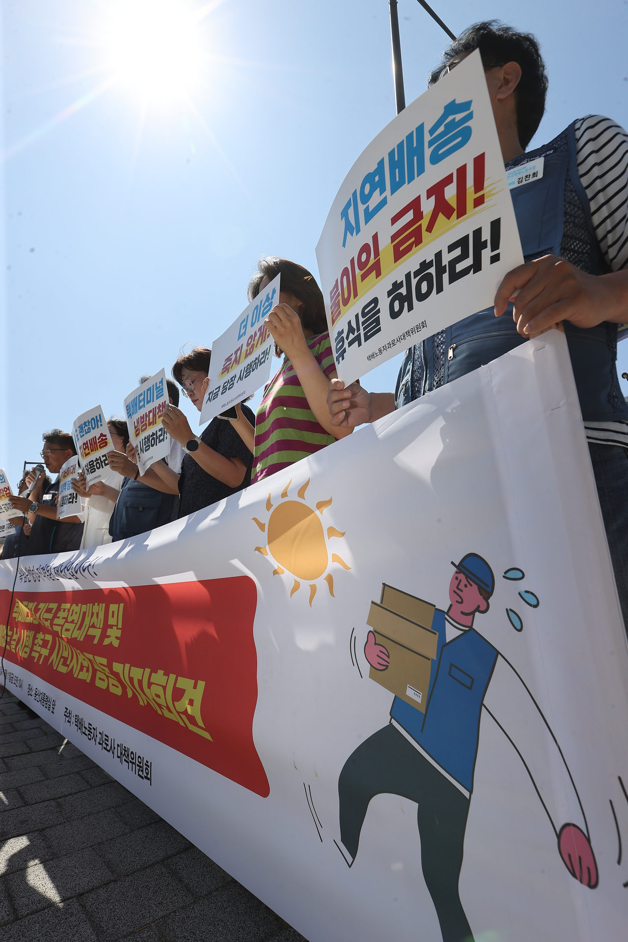 A local express package delivery workers' group holds a press conference calling for government measures to protect their health in the extreme heat, in front of the presidential office in Yongsan-gu, Seoul, Friday. (Yonhap)
