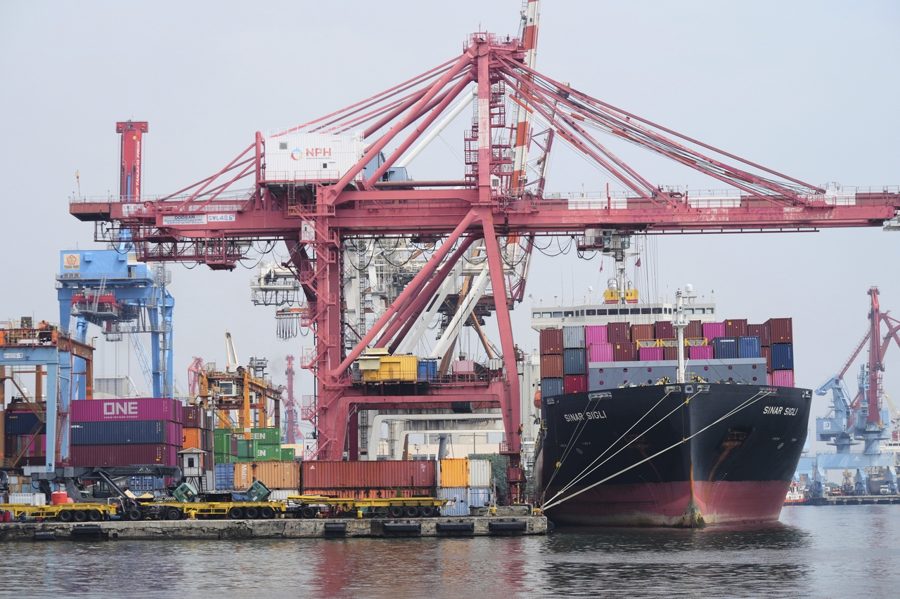 Cranes load shipping containers onto a cargo ship at Jakarta International Container Terminal at Tanjung Priok Port in Jakarta, Indonesia, July 9.   AP-Yonhap