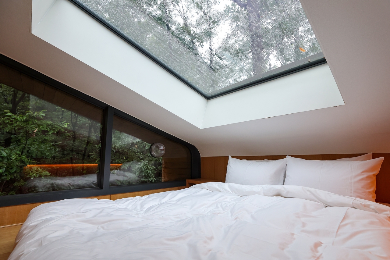 A treehouse suite at Surak Hyu features a glass ceiling for stargazing and panoramic views of the surrounding forest canopy. (Nowon-gu Office)