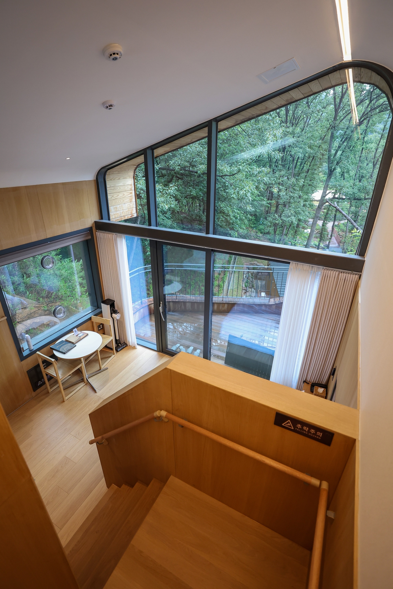 Natural light fills a two-story treehouse unit at Surak Hyu, where full-length windows look directly into the forest. (Nowon-gu Office)