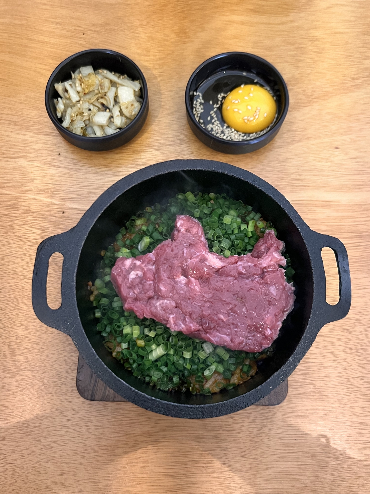 Spicy stir-fried radish kimchi rice topped with cow-shaped "yukhoe," or beef tartare, and green onion served at Junghee in Seosulla-gil, Jongno-gu, central Seoul (Park Jun-hee/The Korea Herald)