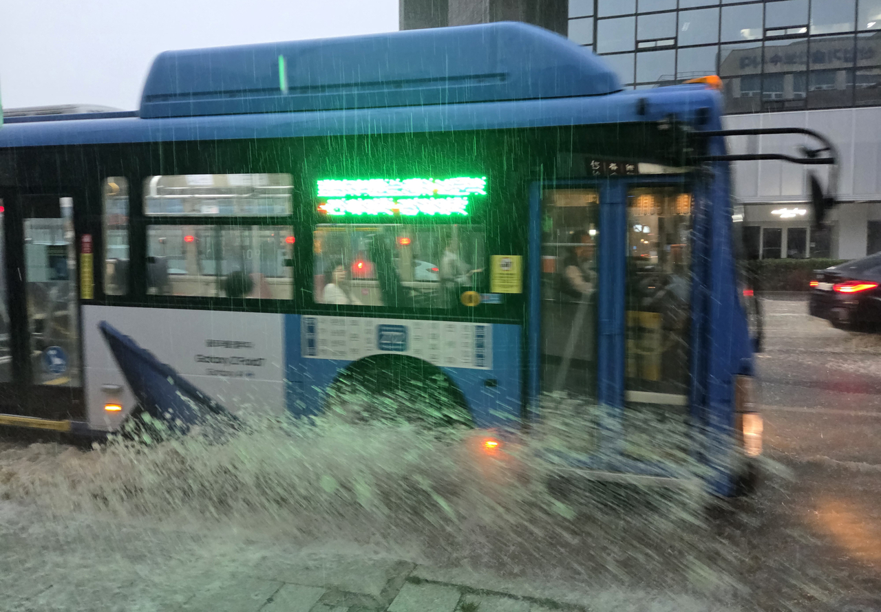 A bus drives through a waterlogged road in Seoul's Jongno-gu on Thursday. (Yonhap)