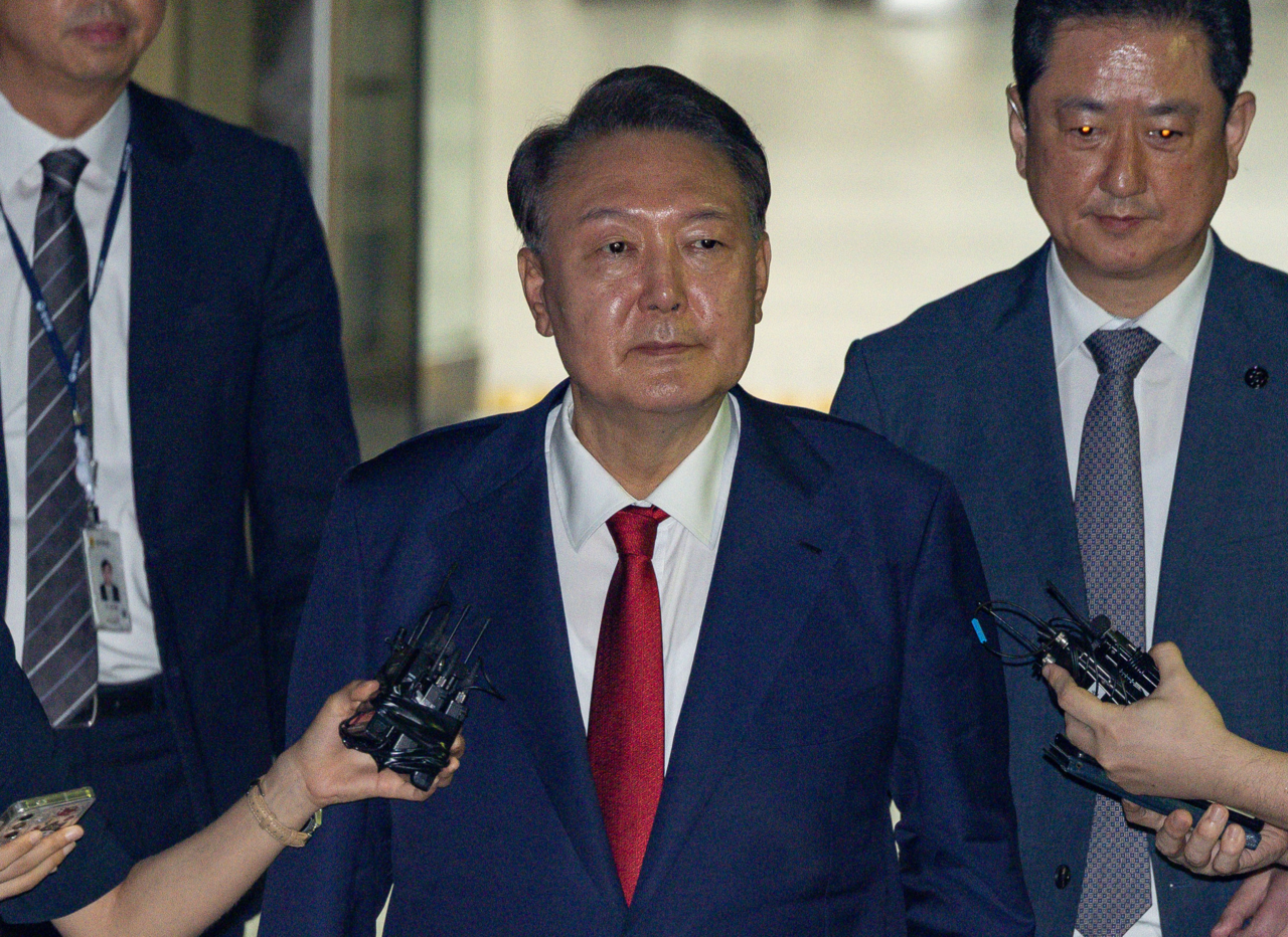 Former President Yoon Suk Yeol (center) exits the Seoul Central District Court in the capital city on July 9, 2025, after attending a hearing on his possible arrest over charges related to his failed attempt to impose martial law. (Yonhap)