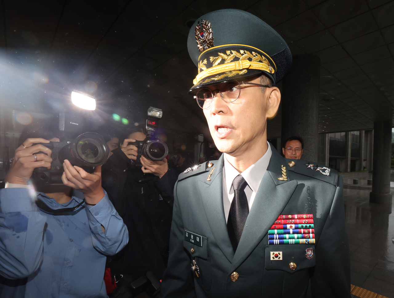 Maj. Gen. Kim Yong-dae (right), commander of the Drone Operations Command, speaks to reporters as he arrives at the Seoul High Prosecutors’ Office in Seocho-gu, Seoul, Thursday. (Yonhap)