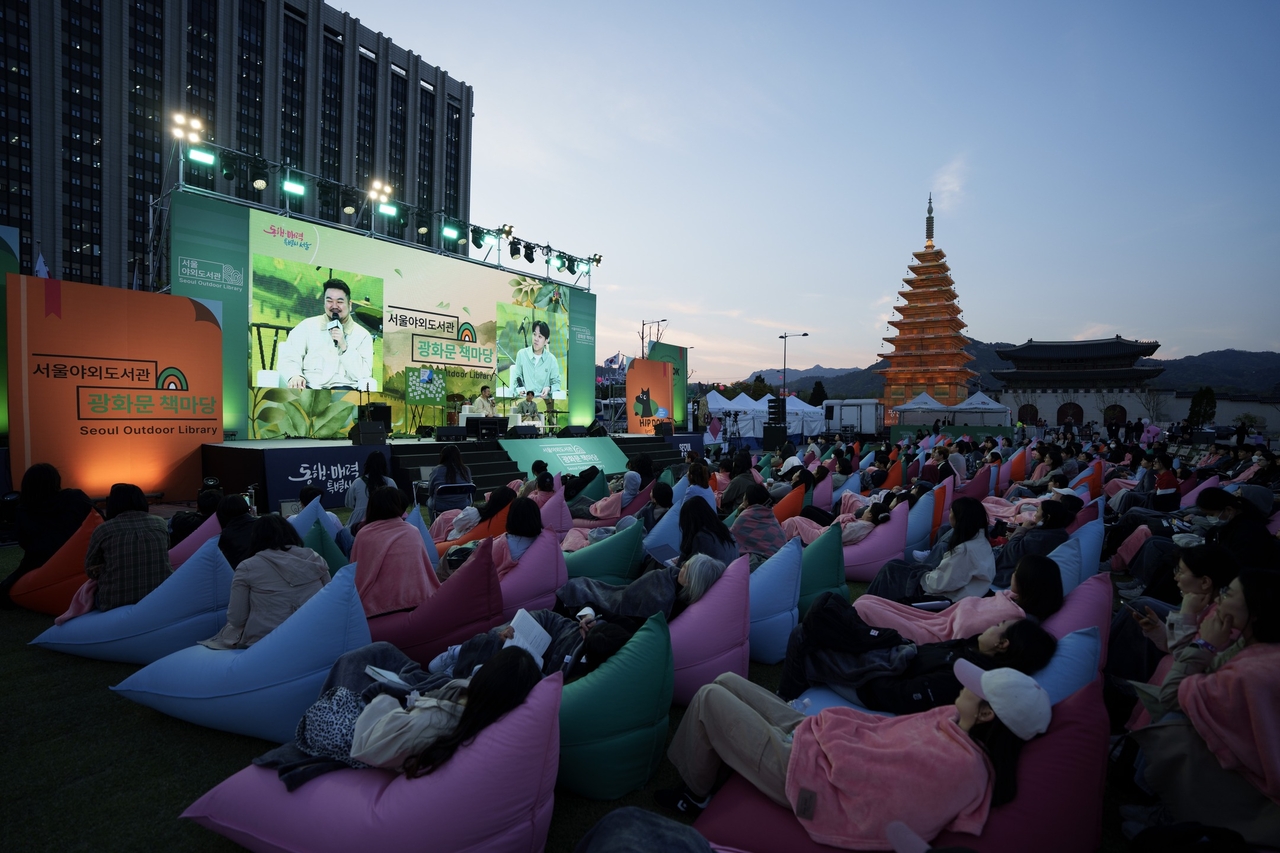 Author Park Sang-young speaks to a full crowd at the Seoul Outdoor Library’s Hip Dok Club event in Gwanghwamun Square. He shared behind-the-scenes stories from writing "Love in the Big City" and reflected on adapting his work for film and television. (Seoul Metropolitan Government)