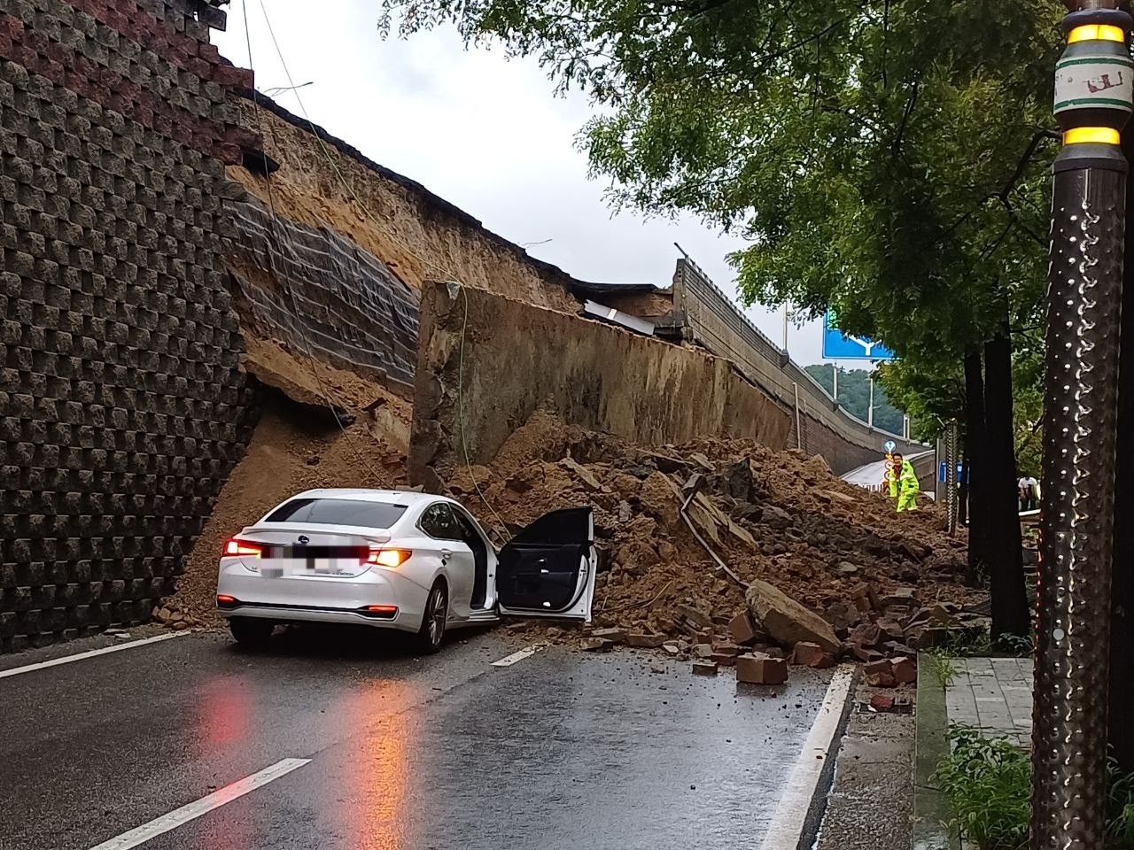 This photo distributed by the rescue authorities in Gyeonggi Province shows a collapsed retaining wall on the side of a road in Osan, Gyeonggi Province, on Wednesday. (Yonhap)