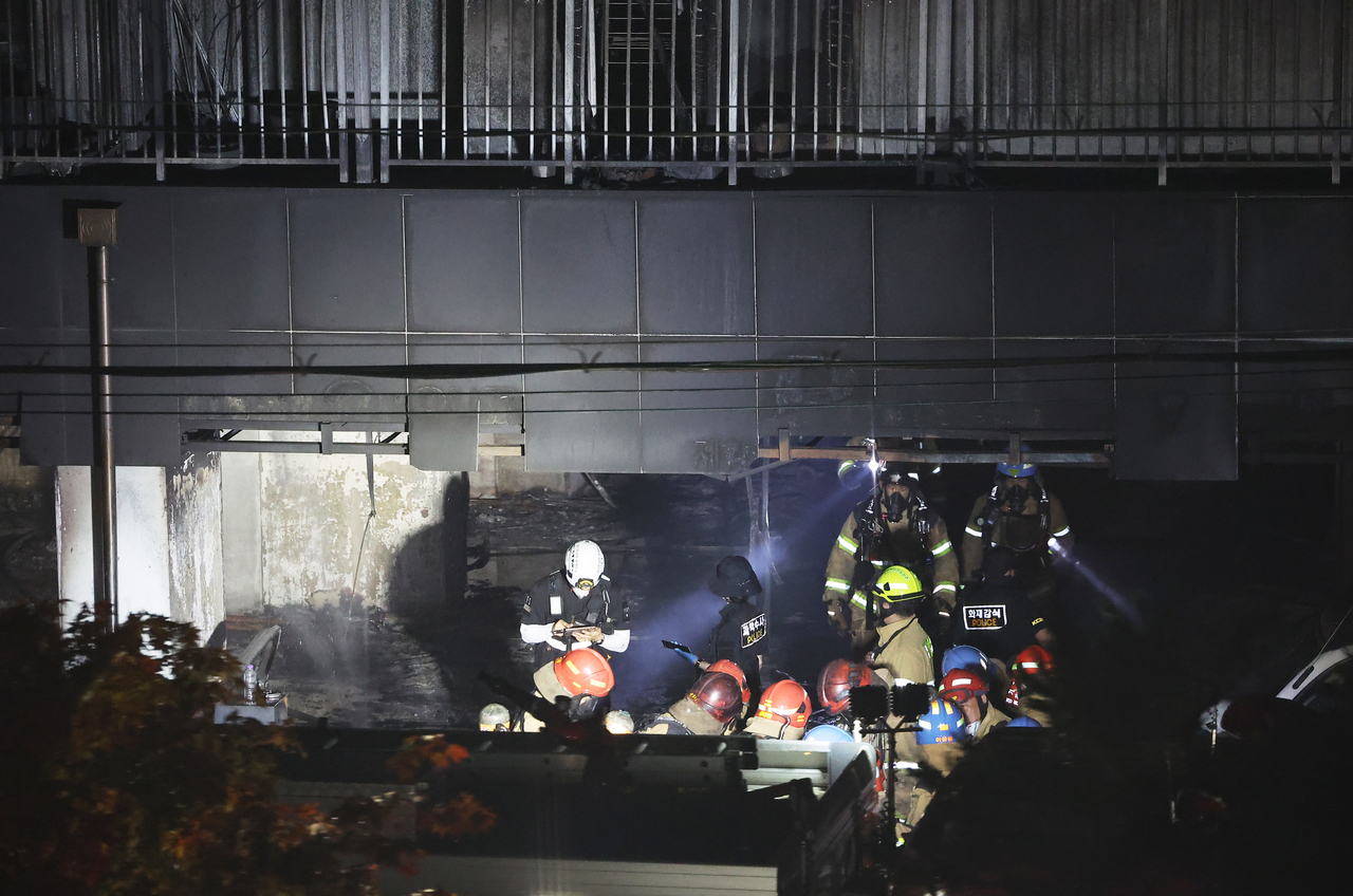 Firefighters conduct search and rescue operations at an apartment building in Gwangmyeong, south of Seoul, on Friday, following a fire that broke out the previous day. (Yonhap)