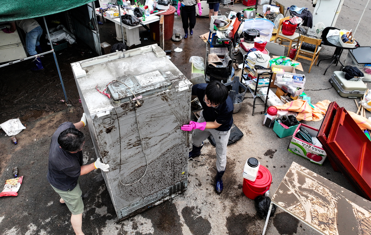 Residents and public officials conduct recovery work on Friday at a house in Daegu flooded by record-breaking heavy rainfall the previous day. (Yonhap)