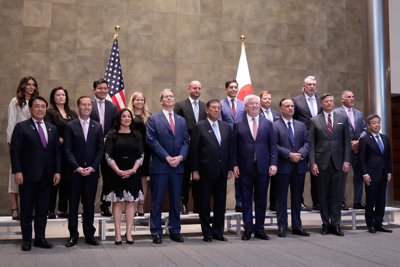 Japanese Prime Minister Shigeru Ishiba (center) and US Treasury Secretary Scott Bessent (fourth from left)  pose for a photo before their meeting at the prime minister's office in Tokyo on Friday. (AFP)