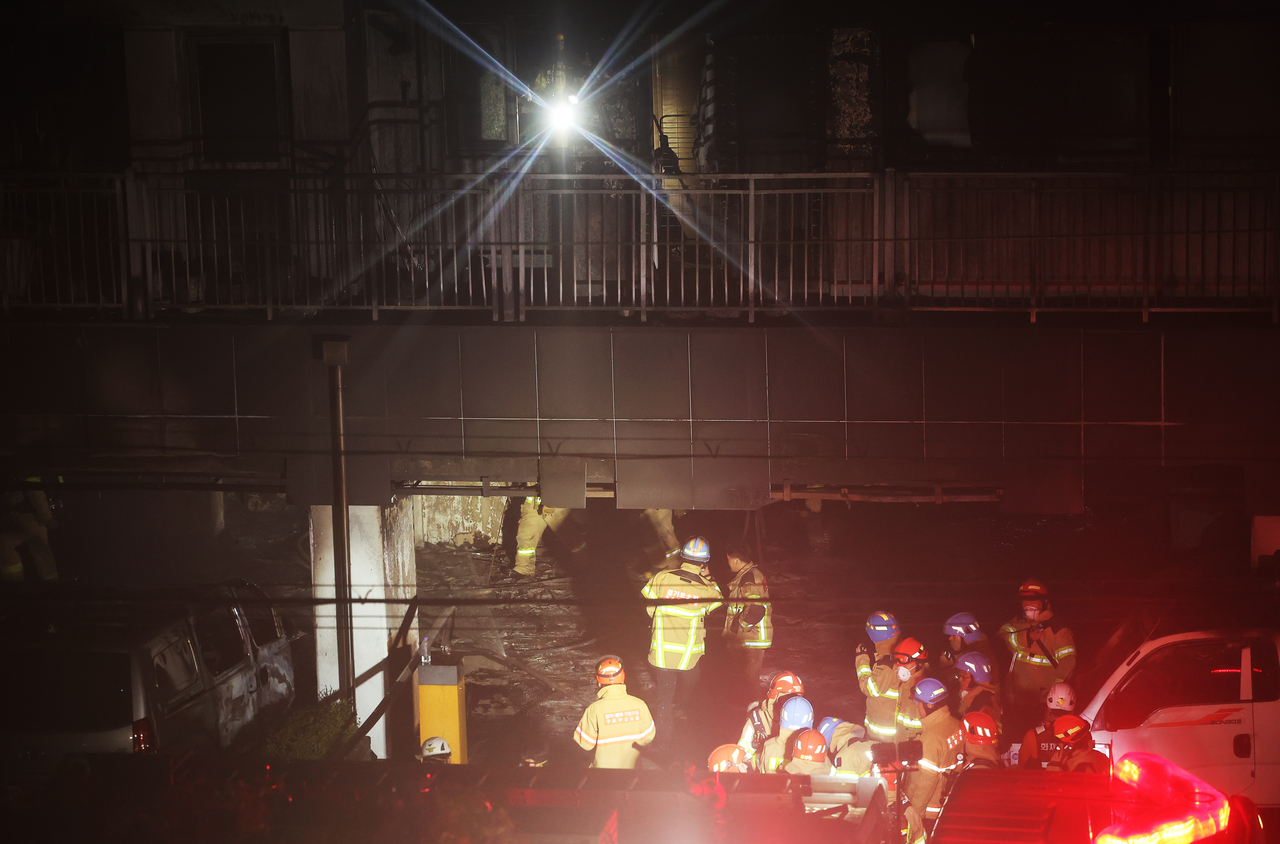 Firefighters are seen inside a gutted apartment  building in Soha-dong, Gwangmyeong, Gyeonggi Province, following a fire. (Yonhap)