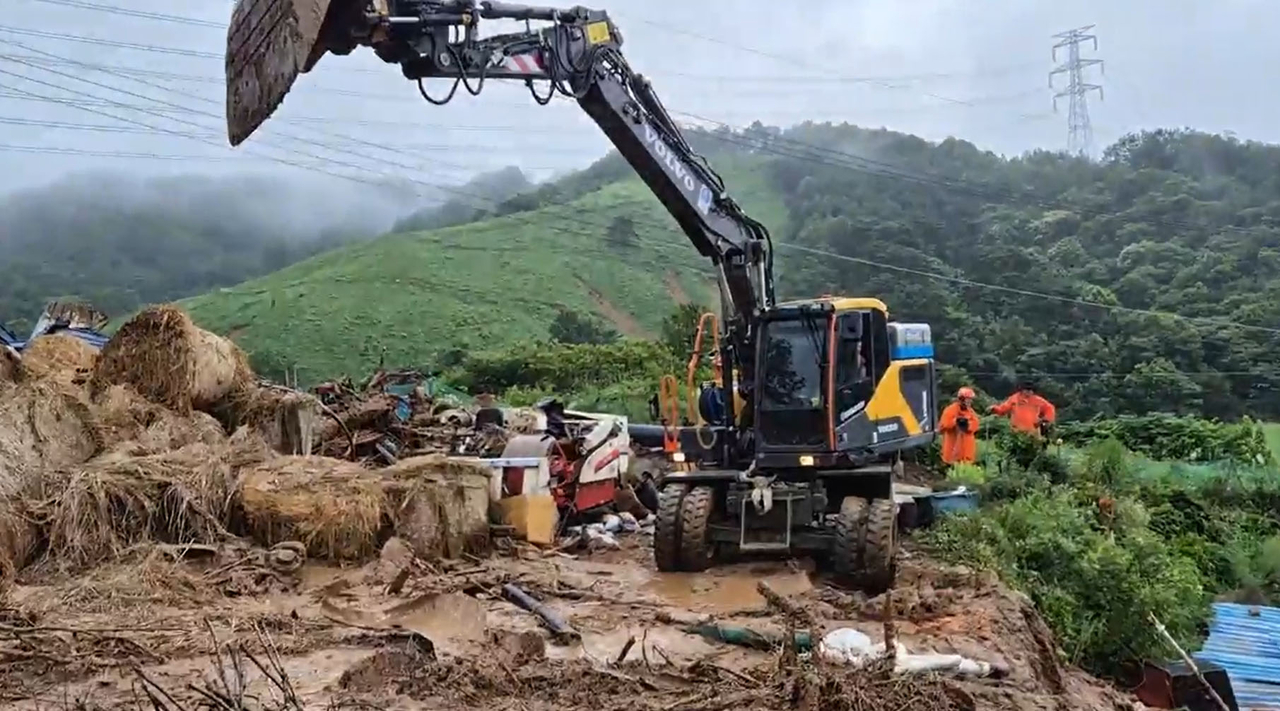 Fire authorities carry out a search operation following heavy downpours and landslides in Sancheong, South Gyeongsang Province, Saturday. (Yonhap)