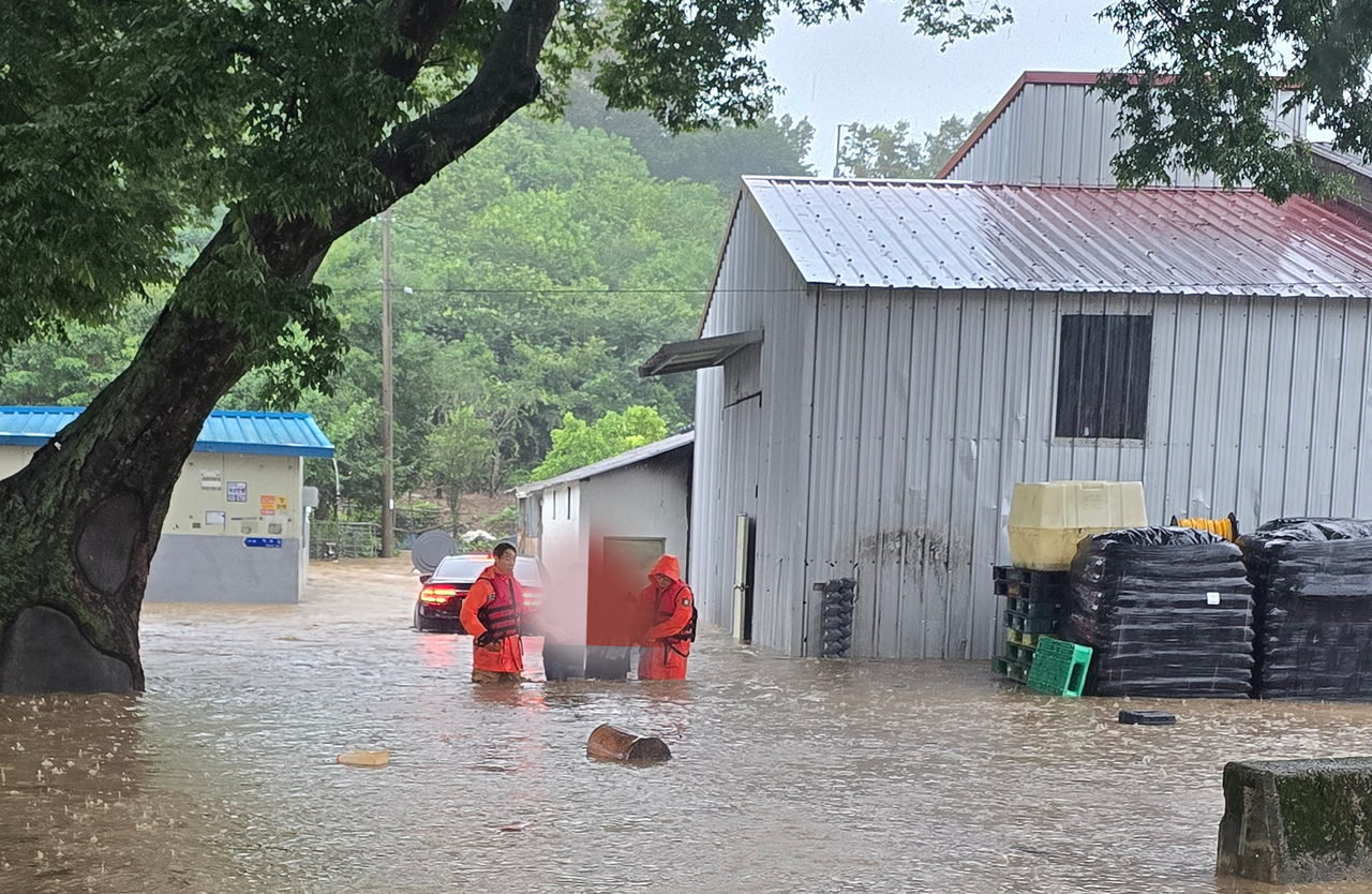 The North Jeolla Province Fire Department rescues residents on Saturday from a village in Seongsu-myeon in Jinan, where a heavy rain warning was issued. (Yonhap)