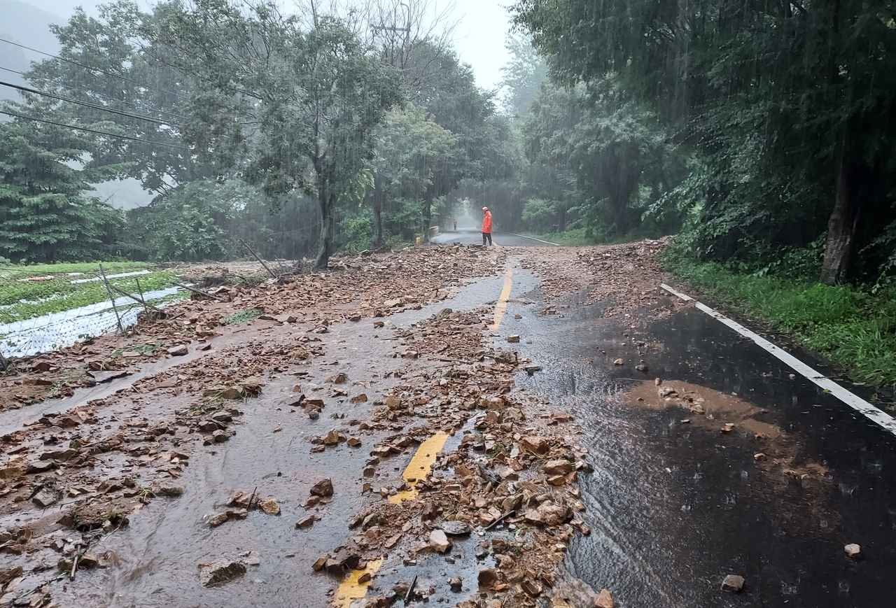 Soil and debris flows onto a road in Cheoncheon-myeon of Jangsu County, North Jeolla Province, where a heavy rain warning was issued Saturday.  (Yonhap)