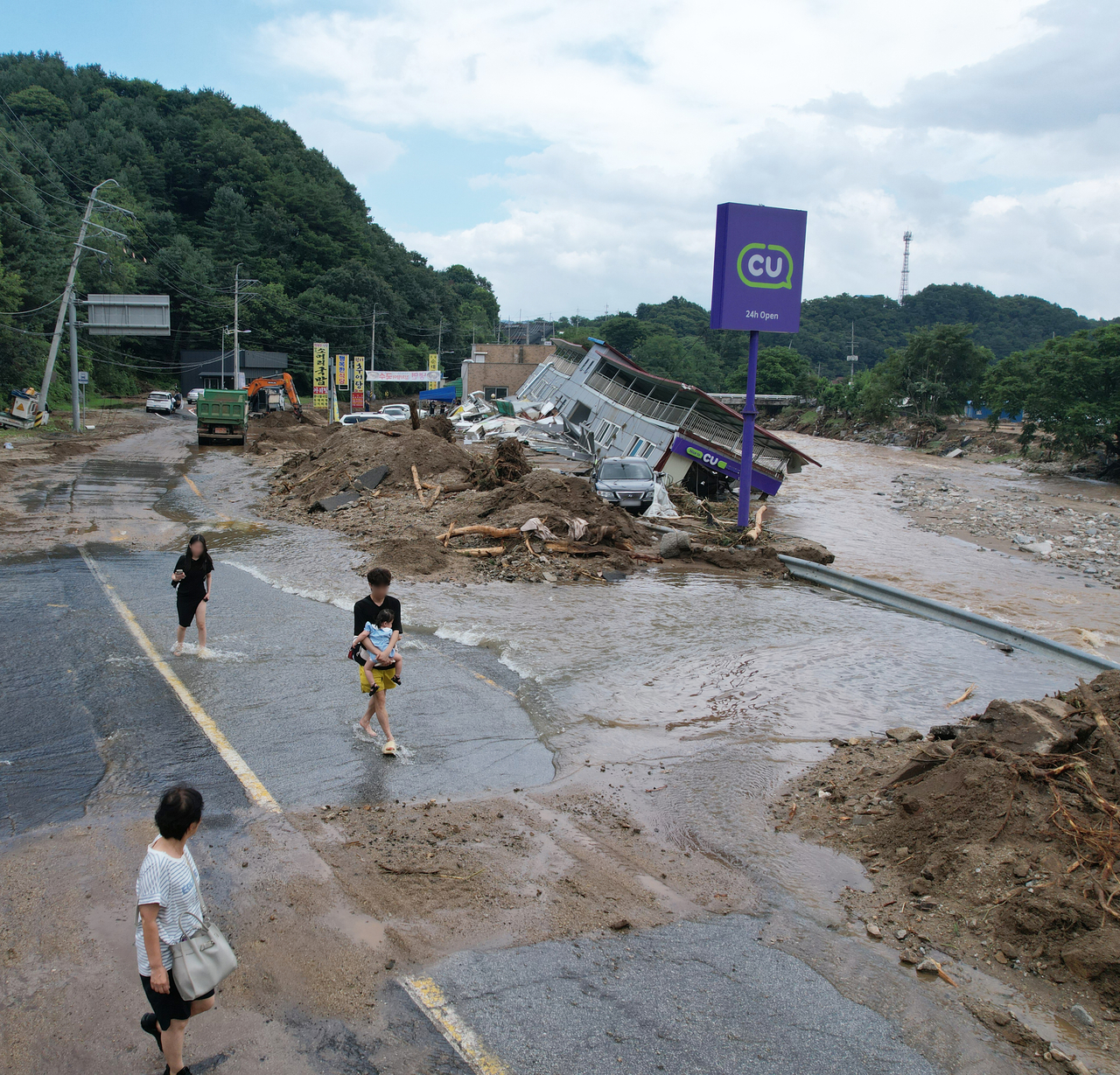 A CU convenience store is seen collapsed into a flooded stream in Gapyeong, Gyeonggi Province, on Sunday. (Yonhap)