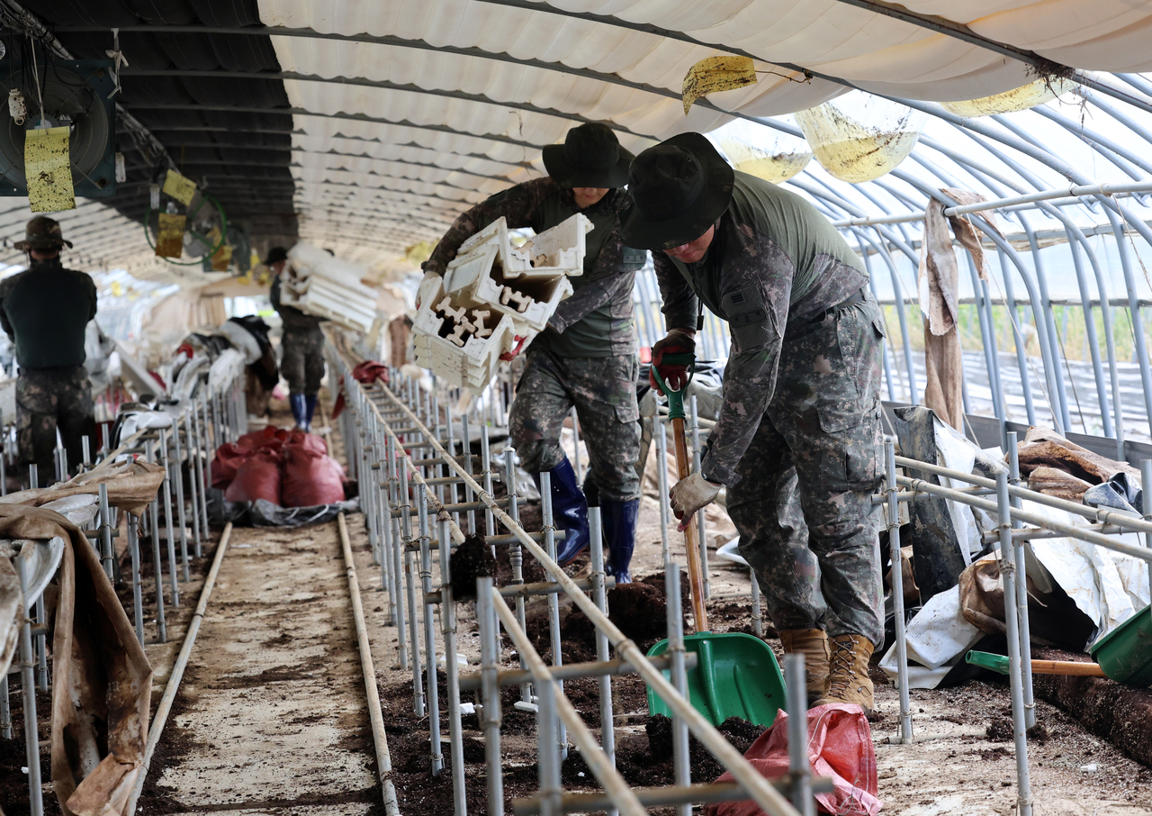 Troops work to restore a strawberry farm flooded by recent heavy rains in Gwangju on Monday, following deadly downpours and landslides. (Yonhap)