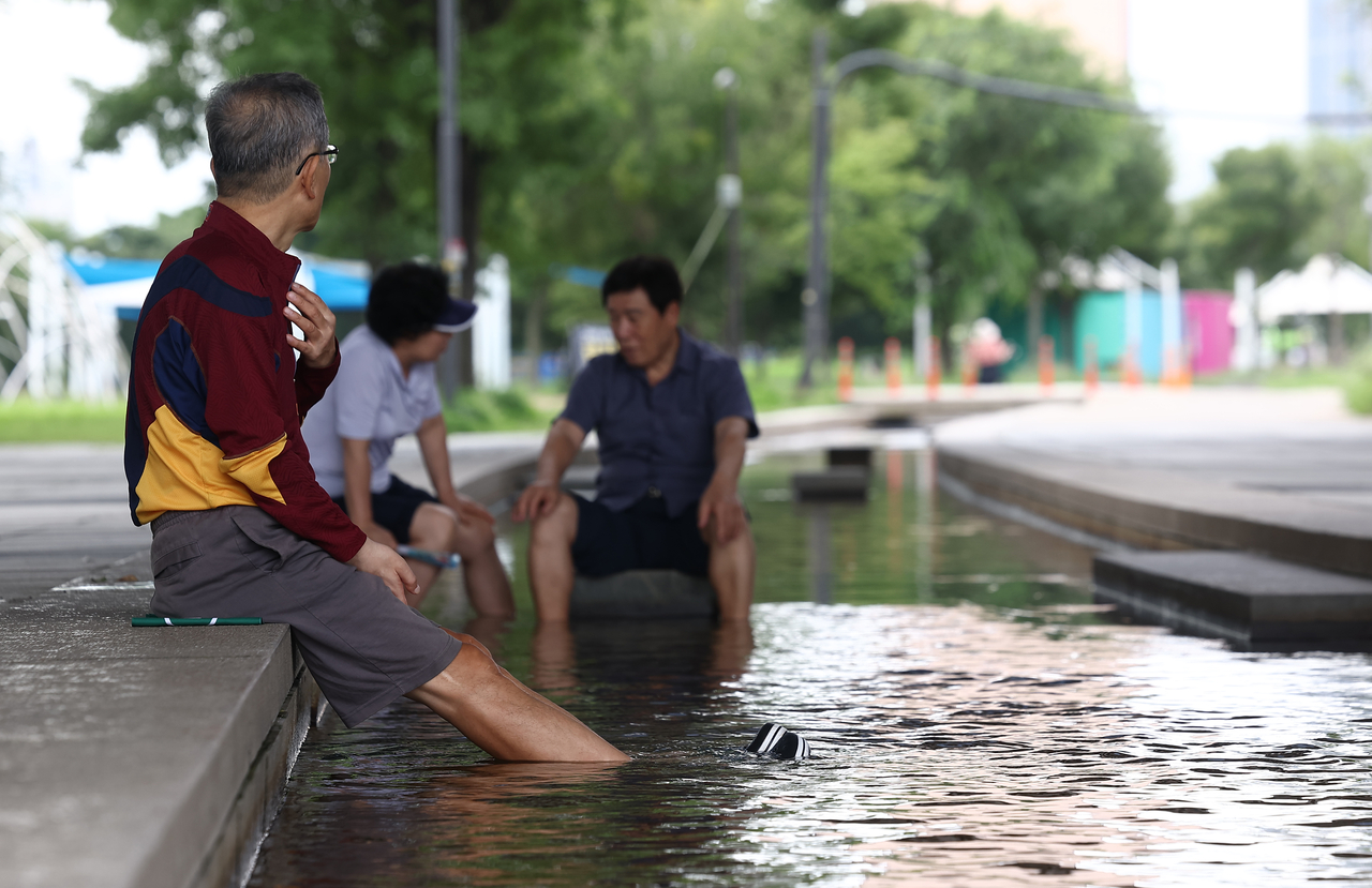 A civilian escapes the heat under the shade at Yeouido Hangang Park in Yeongdeungpo-gu, western Seoul, Monday. (Yonhap)