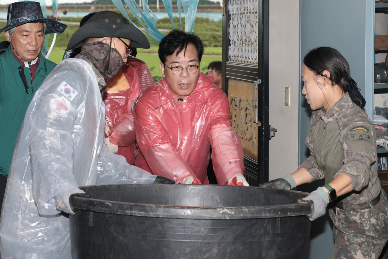 People Power Party interim leader Song Eon-seok and officials join flood recovery efforts in Yesan-gun, South Chungcheong Province, Saturday. (Yonhap)