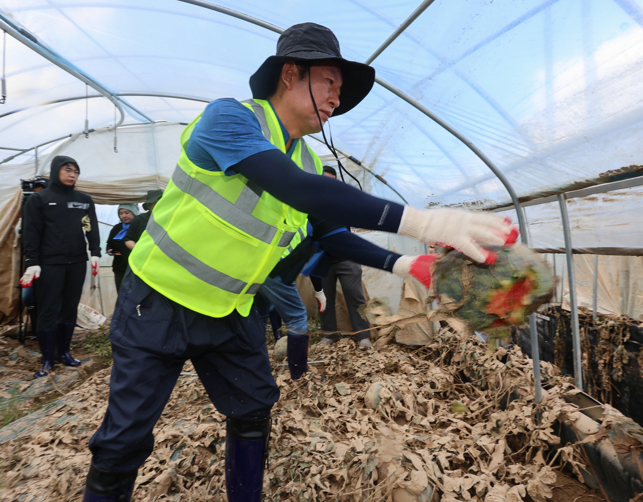 Democratic Party lawmaker Jeong Cheong-rae supports flood recovery efforts in Yesan-gun, South Chungcheong Province, Monday morning. (Yonhap)