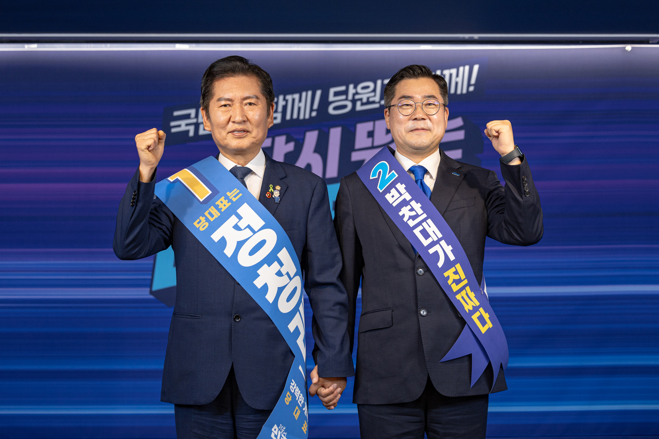 더불어민주당 대표 선거에 출마한 정청래(왼쪽), 박찬대 후보가 19일 서울 여의도 당사에서 열린 합동연설회에서 함께 주먹을 쥐며 인사하고 있다. 더불어민주당 제공