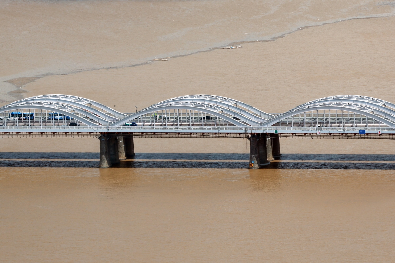 Brown, sediment-heavy water flows beneath Hangang Bridge in Seoul as runoff from recent torrential rains reaches the city. (Yonhap)