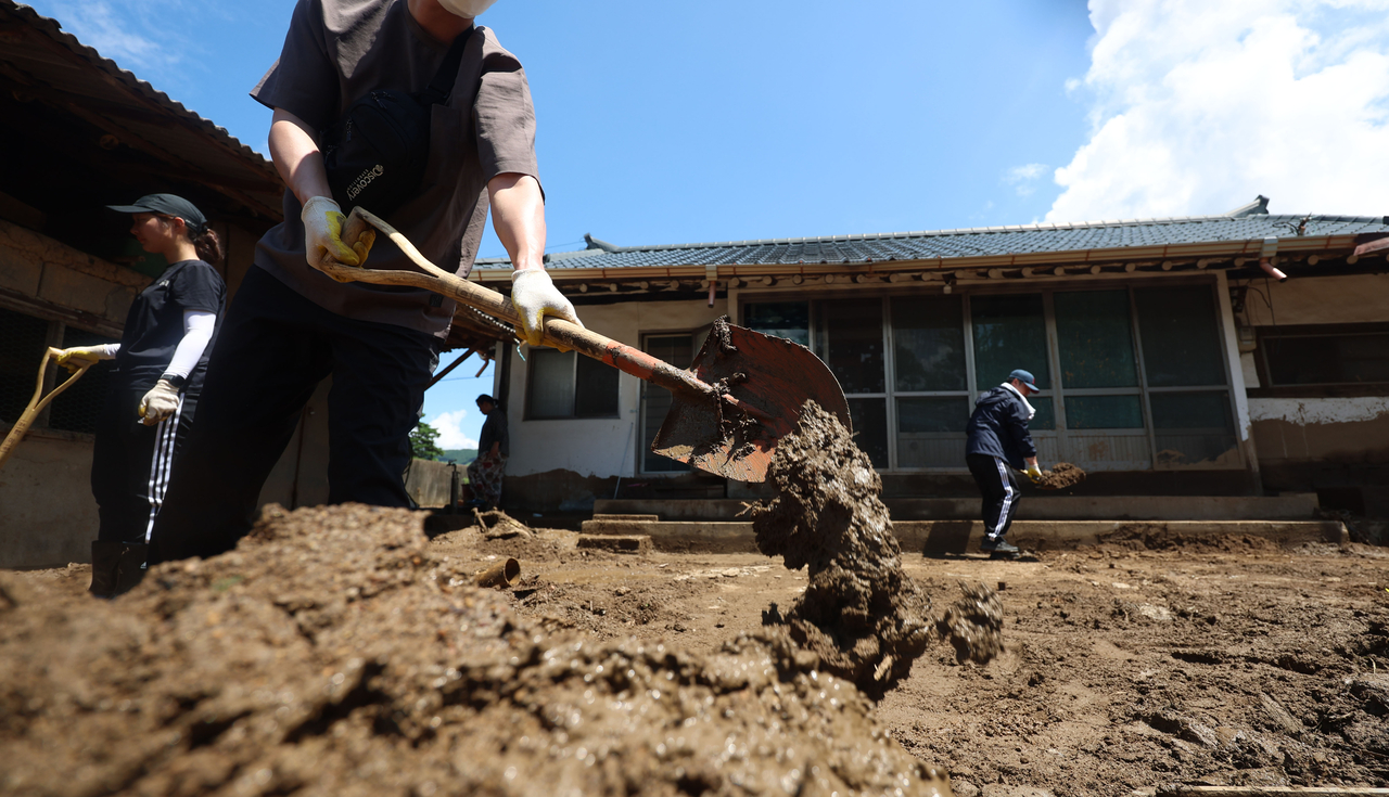Public officials work to recover a house in a flood-damaged village in Sancheong, South Gyeongsang Province, Tuesday. (Yonhap)