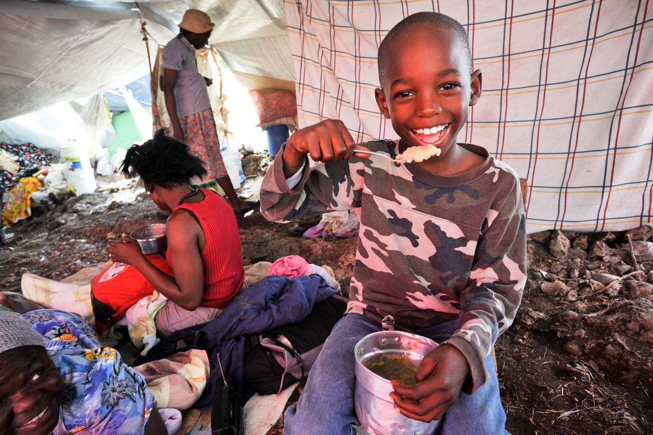 A child in Republic of Haiti smiles at a temporary shelter provided by World Vision. (World Vision)