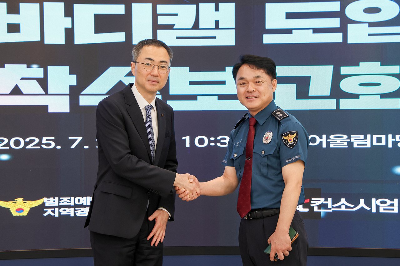Yoo Yong-kyu, head of the Enterprise Public Sector Division at KT, and Ko Pyeong-gi, director general of the Crime Prevention and Response Bureau at the National Police Agency, pose for a photo during the contract signing ceremony for supplying 14,000 body cameras for police officers on Wednesday at the National Police Agency. (KT)