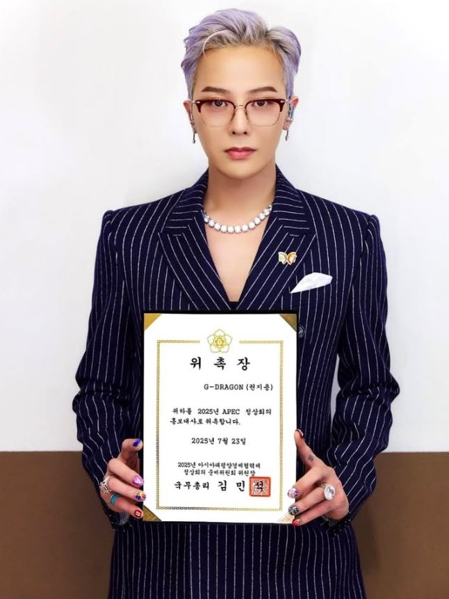 G-Dragon holds a letter of appointment from Prime Minister Kim Min-seok after being named the honorary ambassador for APEC 2025, to be held in Gyeongju, North Gyeongsang Province. (G-Dragon's Instagram account)