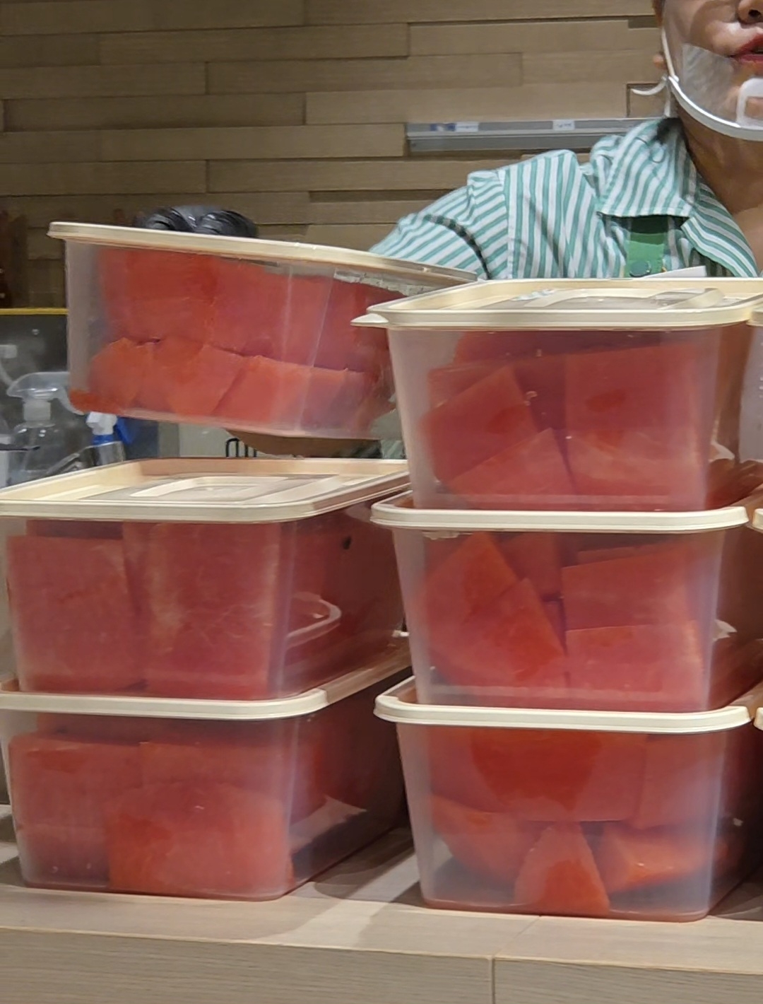 A customer's watermelon is sliced up and packed into several containers. (Song Seung-hyun/The Korea Herald)