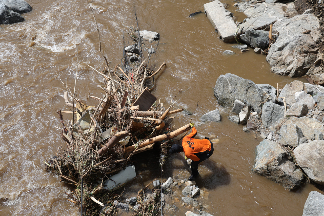 This photo provided by South Gyeongsang Province on Tuesday, shows a rescue worker searching for missing people from heavy rains that ravaged the country earlier in the month. (Yonhap)