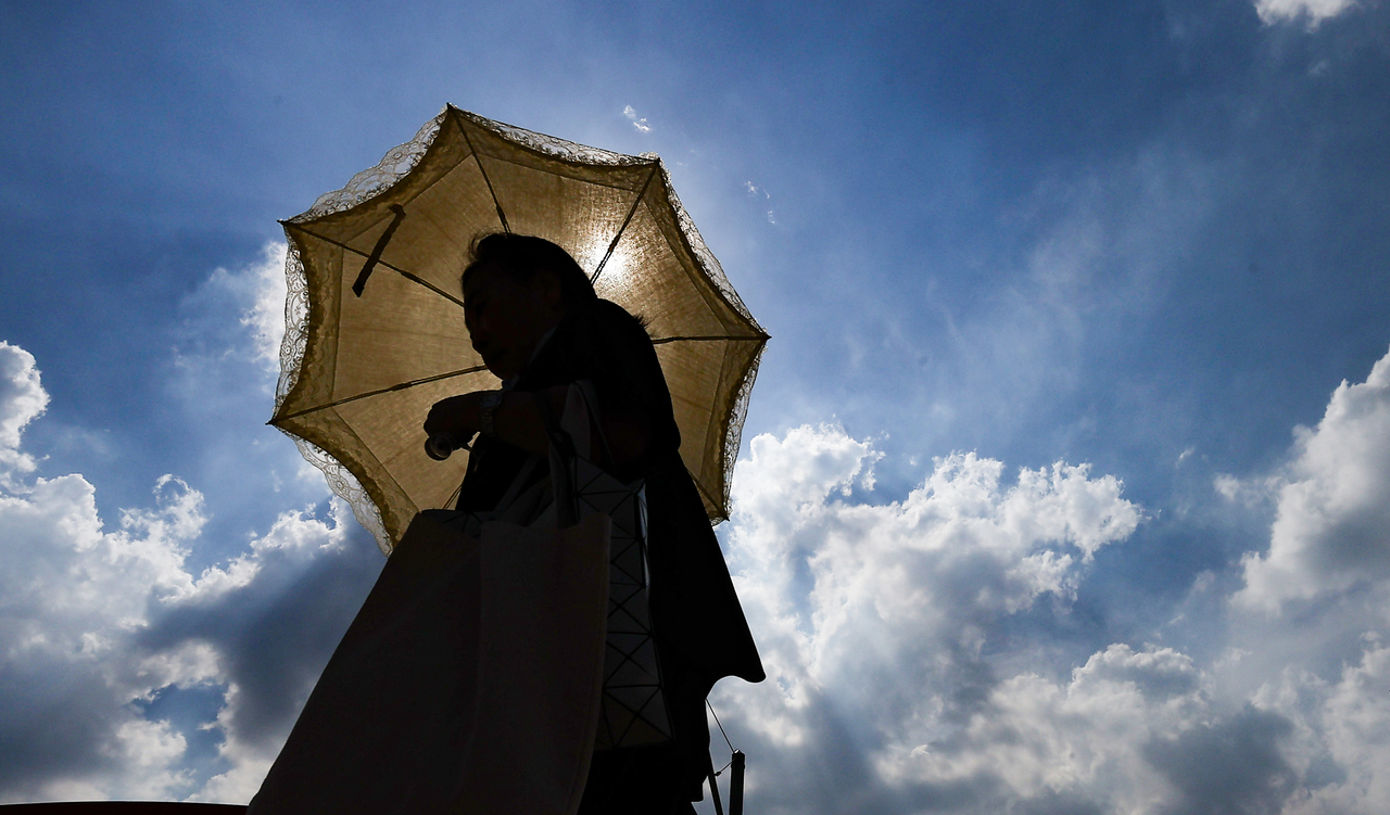 A pedestrian walks outside with a parasol in Daegu on Wednesday, as heat wave warnings were issued throughout the city that day. (Yonhap)