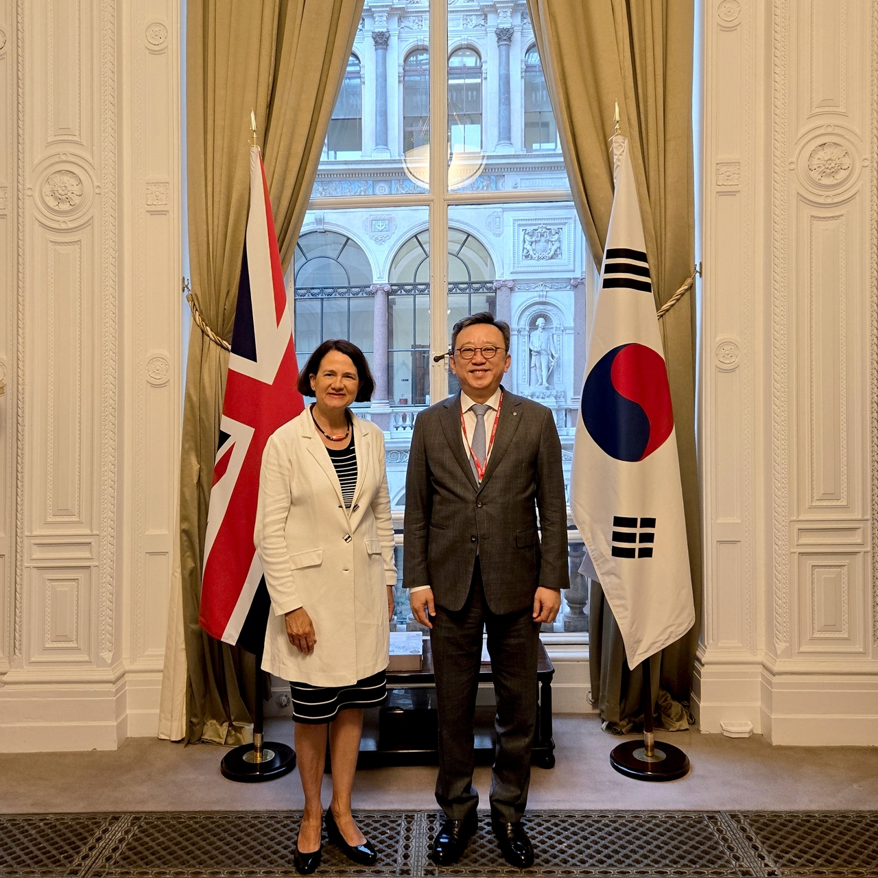 Shinhan Bank CEO Jung Sang-hyuk (right) and Catherine West, parliamentary under-secretary of state for the FCDO’s Asia-Pacific region, pose for a photo after their meeting in London on Tuesday. (Shinhan Bank)